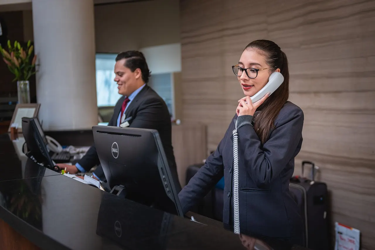 Recepcionista atendiendo una llamada en un mostrador